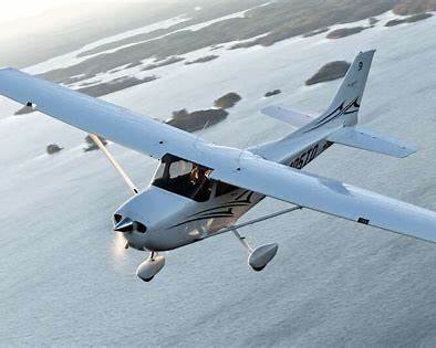 Cessna 172 single-engine trainer aircraft in flight at golden hour